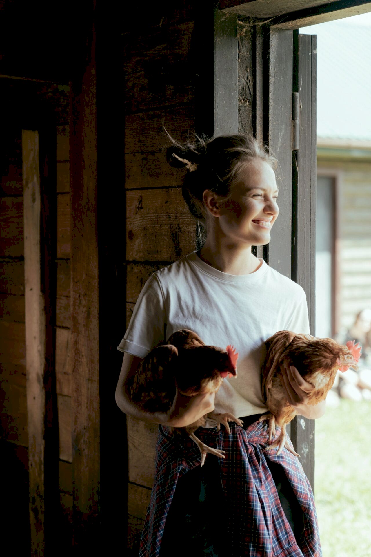 Chicken farmer holding two chickens