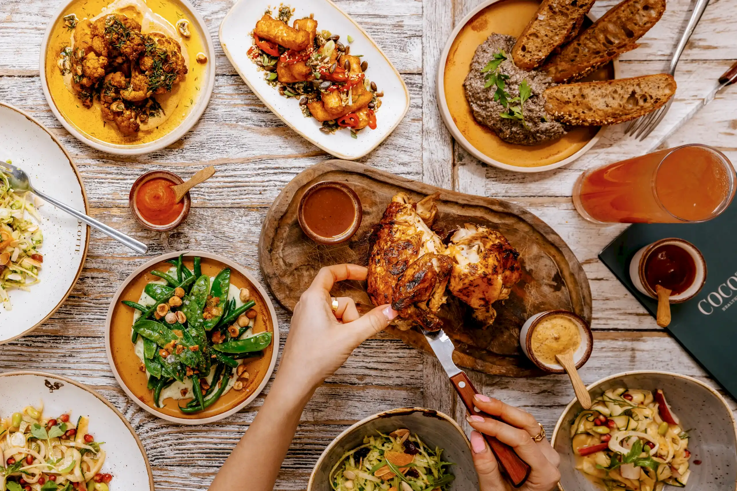 Customer eating chicken and side dishes at Cocotte